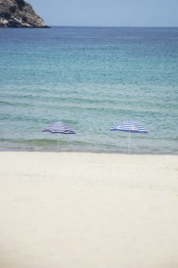 Boş sahilde iki şemsiye