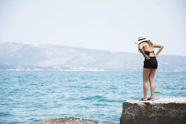 Fashionabla kvinna på sten däck på seaside — Stockfoto