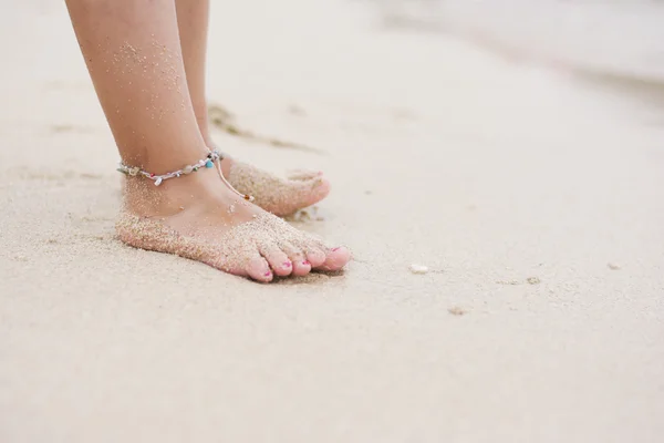 Bambino scalzo con braccialetto alla caviglia sulla spiaggia — Foto Stock