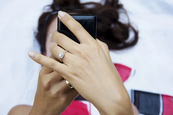 Jolie femme brune utilisant un smartphone dans le parc — Photo