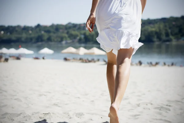 Mulher de branco correndo na praia — Fotografia de Stock