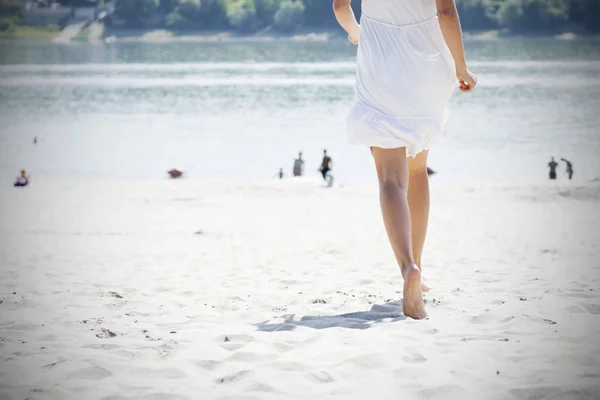 Femme en blanc courant sur la plage — Photo