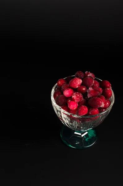 Arándanos congelados en un recipiente de vidrio sobre fondo negro — Foto de Stock