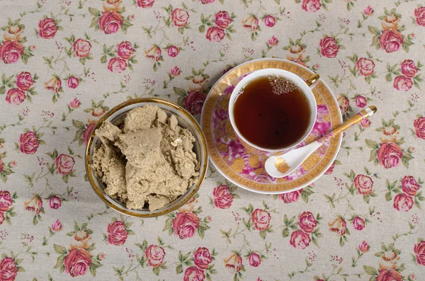 Egy csésze tea és finom halva a csészealj — Stock Fotó