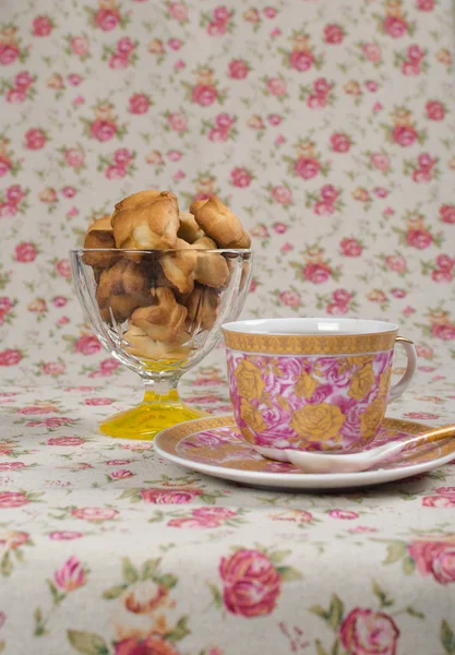 Cookies in een rieten mand en een kopje thee — Stockfoto