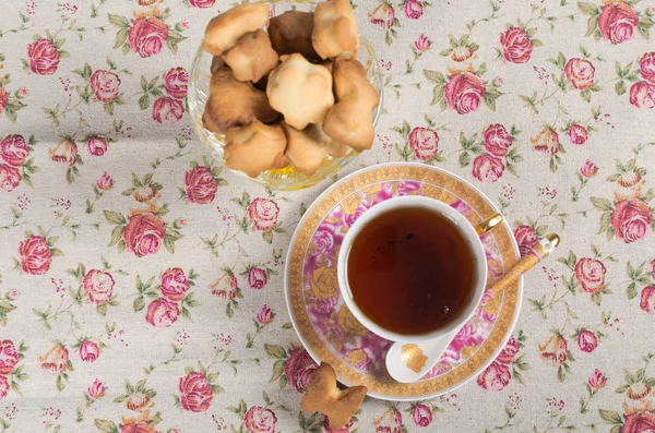 Soubory cookie v proutěném koši a šálek čaje — Stock fotografie