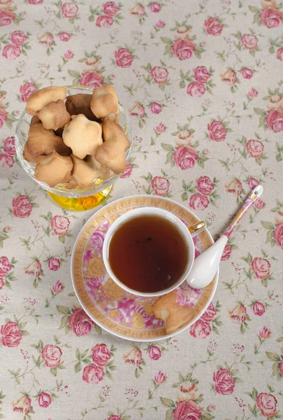 Ciasteczka w wiklinowym koszu i filiżankę herbaty — Zdjęcie stockowe