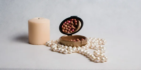 Koraliki perłowe, pudełko rouge i białe okrągłe świeca na lekki b — Zdjęcie stockowe