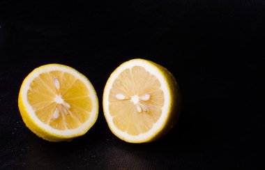 Siyah bir arka plan üzerinde Su damlacıkları sulu limon yarısı