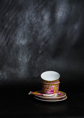 iki vintage bardak, sauceres ve siyah bir zemin üzerine kaşık