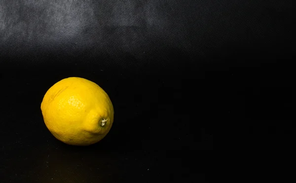 Studio shot of single lemon isolated on black background — Stock Photo, Image