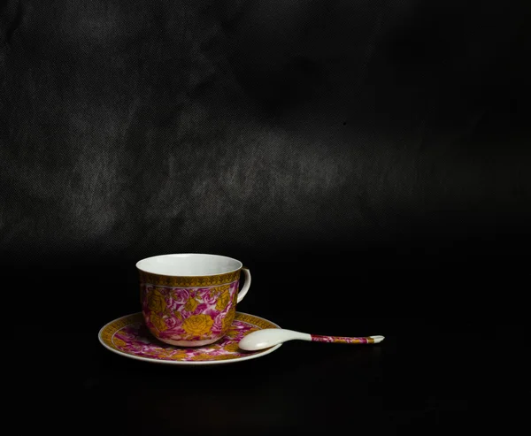 Vintage cup, talerzyk i łyżka na czarnym tle — Zdjęcie stockowe