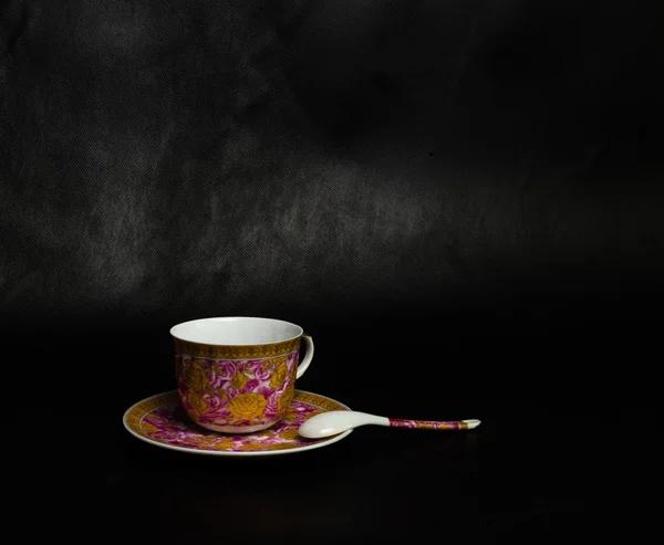 Tazza vintage, piattino e cucchiaio su sfondo nero — Foto Stock