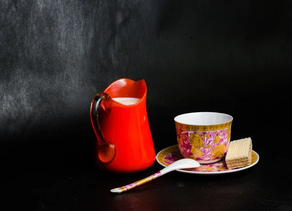 Copo antigo e pires e leite em um frasco de vidro laranja e wafer — Fotografia de Stock