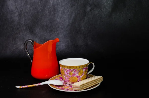 Antieke kop en schotel en melk in een glazen pot oranje en wafer — Stockfoto