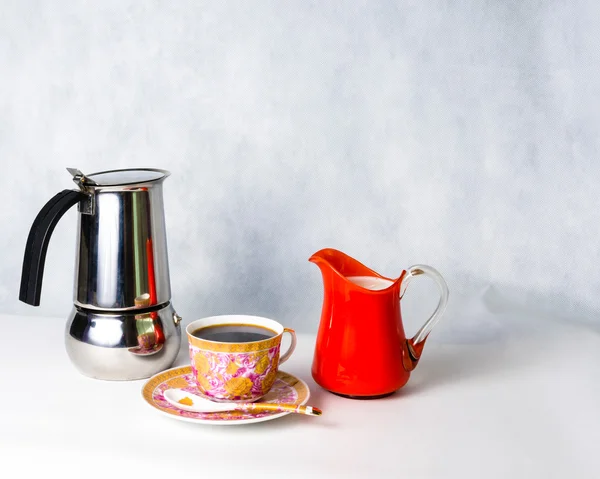 Tazza antica, piattino, latte in un barattolo di vetro arancione e caffettiera — Foto Stock