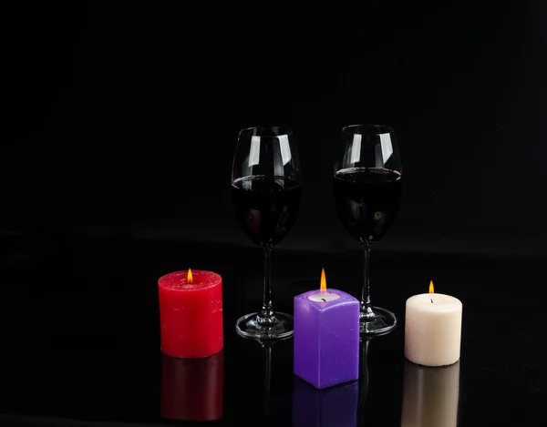 Sklenice vína a svíčka na černém pozadí — Stock fotografie