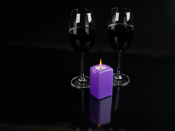 Glass of wine and a candle on a black background — Stock Photo, Image