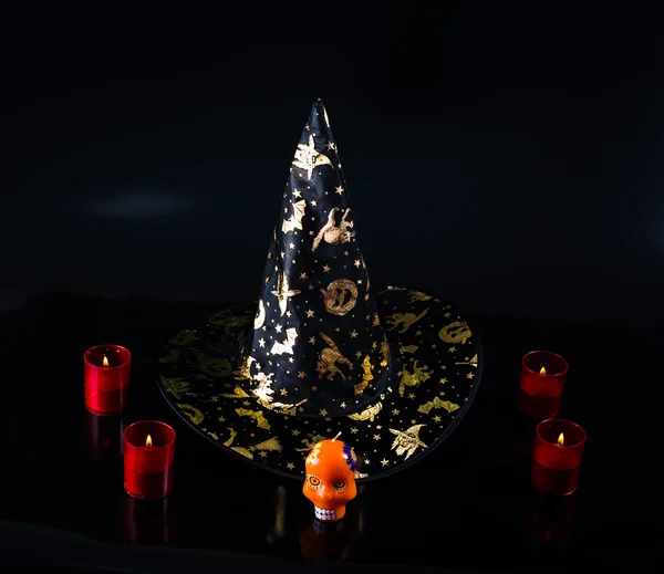 Black fabric witch hat, candles isolated on black background — Stock Photo, Image