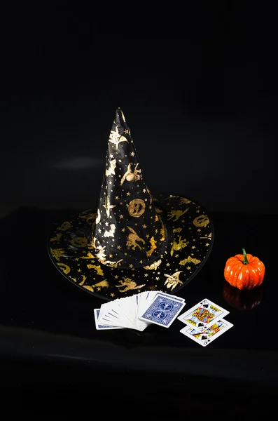 Black fabric witch hat, pumpkin isolated on black background — Stock Photo, Image