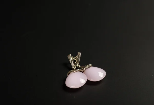 Earring met kleurrijke roze edelstenen op zwarte achtergrond — Stockfoto