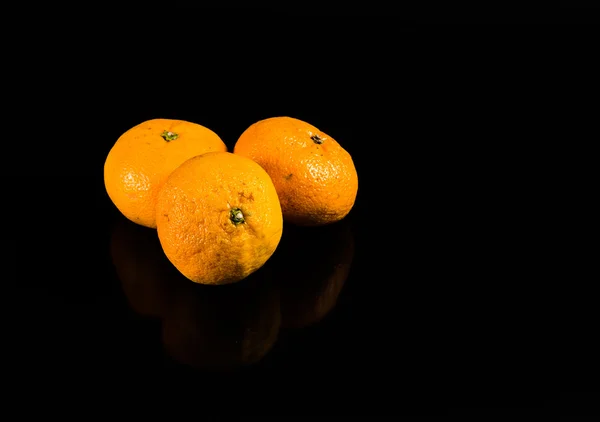 Mandarine isoliert auf schwarzem Hintergrund mit Reflexion — Stockfoto
