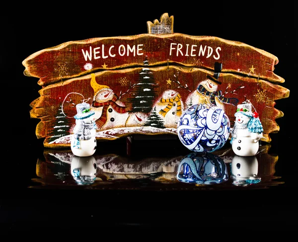 Christmas snowman op zwarte achtergrond met bord. Kerstmis — Stockfoto