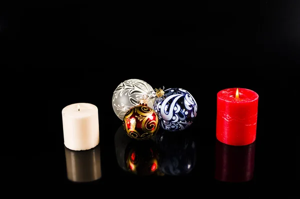 Bola de Navidad y velas aisladas sobre fondo negro — Foto de Stock