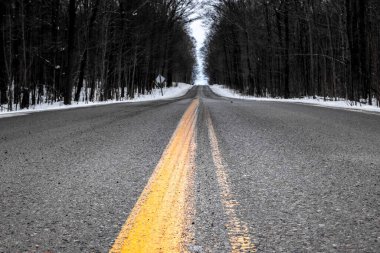 2021 'de Kanada' nın gri bir kış gününde Middlesex County 'de asfalt asfalt bir yolda sarı çizgiye yaklaştık.. 