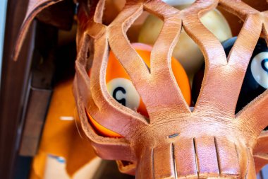 A criss-cross leather pool table pocket holds an 5 ball, Toronto, Ontario, Canada.