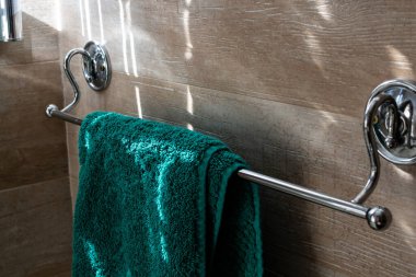 A blue terry towel hangs on a silver rack in an interior shot of a guest bathroom, London, Ontario, Canada.