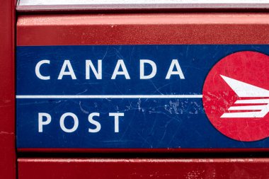 London, Ontario, Canada - February 15 2021: Red, blue and white Canada post metal letterbox, crisp shot and closeup of the logo.