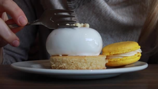 2021年2月 2本のシルバーフォークでハート型のバニラパッションフルーツケーキにカット ホワイトセラミックプレートの側面にマンゴーとパッションフルーツのクリームフレンチマカロン — ストック動画