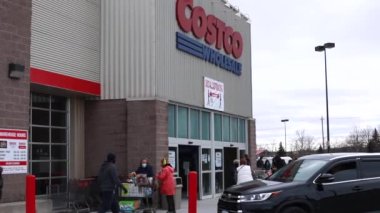 Londra, Ontario, Kanada - 7 Mart 2021: Kalabalık Costco 'dan Harikalar Diyarı' nda ayrılıyor, sağlık maskeleri takıyor, diğerleri ise içeri girip alışveriş yapmak için sıraya giriyor. 