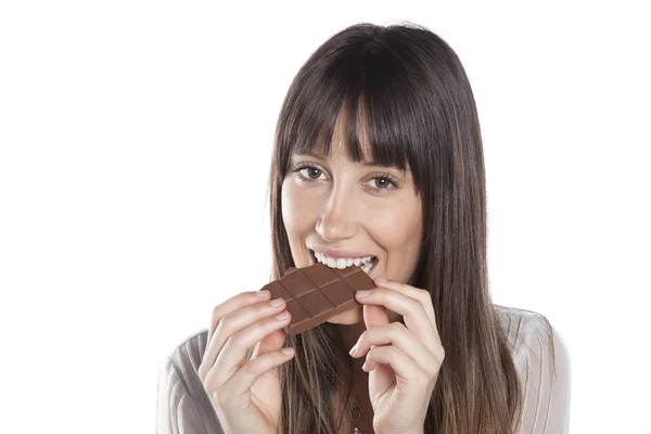 Mulher a comer chocolate. Menina bonita mordendo uma barra de chocolate — Fotografia de Stock