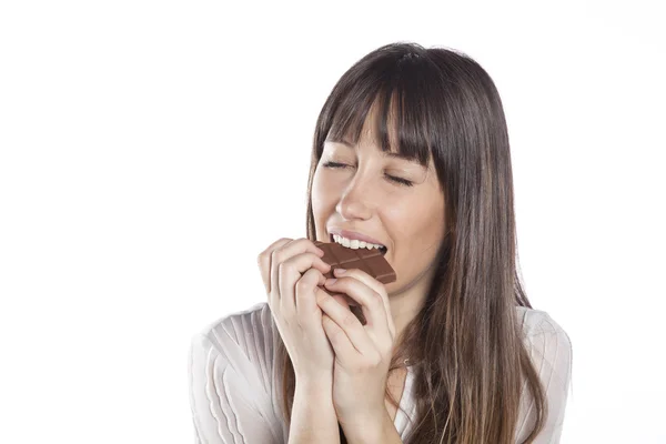 Une femme qui mange du chocolat. Belle fille mordre une barre de chocolat — Photo