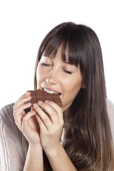 Mulher a comer chocolate. Menina bonita mordendo uma barra de chocolate — Fotografia de Stock