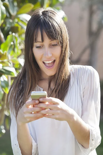 Улыбающаяся женщина пишет смс на смартфоне — стоковое фото