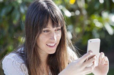 Bir akıllı telefon üzerinde gülümseyen kadın manifatura