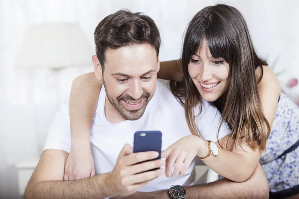 En bild av ett ungt par med en telefon — Stockfoto