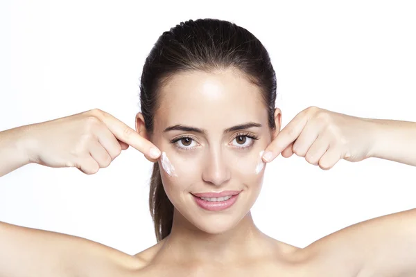 Retrato de una hermosa mujer aplicando crema en la cara — Foto de Stock