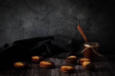 Koyu arkaplanda çikolata parçacıklı kurabiyeler ve sıcak çikolata. Huysuz yemek fotoğrafı.