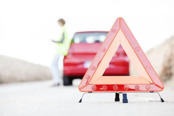 Kadın kırmızı bir arabanın yanında duran bir servise sesleniyor.