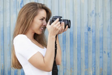 Genç kadın alarak fotoğraf ile dijital fotoğraf makinesi, yan görünüm