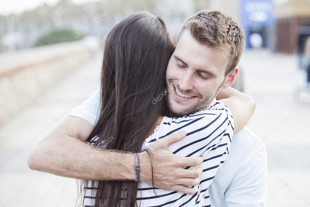 Happy teen couple embracing at street