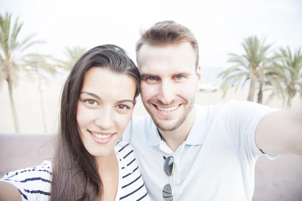 Pareja feliz tomando una foto selfie con una cámara. Sonriendo. —  Fotos de Stock