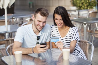 Çift tatil günlerinde bir dizüstü bilgisayar ve teras bar üzerinde kredi kartı ile online satın alma