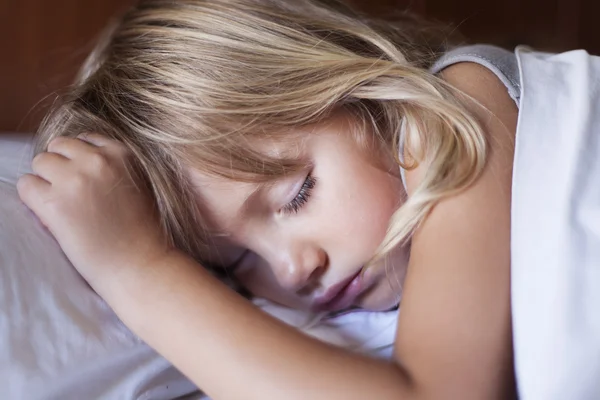 Bedårande liten flicka sova i en säng — Stockfoto