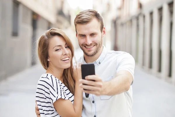 Diversão casal tirar fotos de auto-retrato com telefone inteligente móvel — Fotografia de Stock