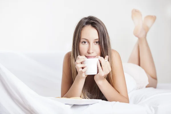 Wanita di tempat tidur minum kopi. Wanita menikmati kopi di tempat tidur di pagi hari — Stok Foto